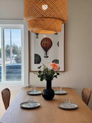 a dining room table with a vase of flowers on it at Cozy Private Room C in S Central LA in Los Angeles