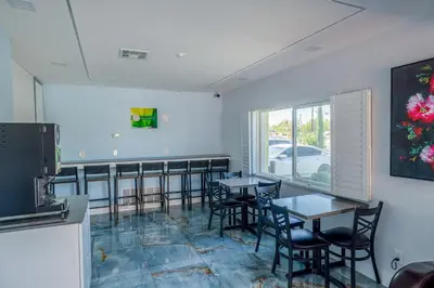 a dining room with tables and chairs and a window at Hotel Avenida Victorville I 15 in Victorville