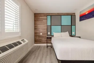a bedroom with a large bed and a window at Hotel Avenida Victorville I 15 in Victorville