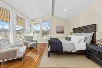 a bedroom with a bed and a chair and windows at A California Country Experience - Tehachapi in Tehachapi