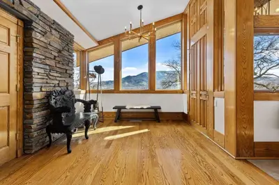 a living room with a chair and large windows at A California Country Experience - Tehachapi in Tehachapi
