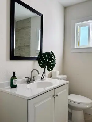 a bathroom with a sink and a toilet and a mirror at Cozy private Room D in S Central LA in Los Angeles