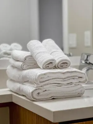 a stack of towels sitting on a counter in a bathroom at Walk to Santa Monica Beach & Pier I Free Parking! in Los Angeles