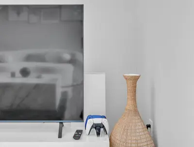 a vase sitting on a table next to a tv at High Ceilings 3BR with Loft-2 Baths Pool & Jacuzzi in Tarzana