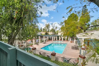 a swimming pool in a yard with a fence at High Ceilings 3BR with Loft-2 Baths Pool & Jacuzzi in Tarzana