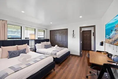 a hotel room with two beds and a desk and a desk at Off Grid Mountaintop Paradise Pool Spa and Games in San Bernardino