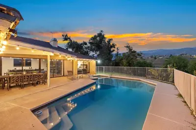 a swimming pool in the backyard of a house at Off Grid Mountaintop Paradise Pool Spa and Games in San Bernardino