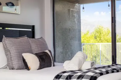 a bedroom with a bed and a large window at Off Grid Mountaintop Paradise Pool Spa and Games in San Bernardino