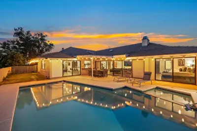 a swimming pool in front of a house at Off Grid Mountaintop Paradise Pool Spa and Games in San Bernardino