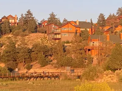 a group of houses on a hill with a bridge at Spacious cozy chalet huge deck over seasonal creek in Big Bear City Airport