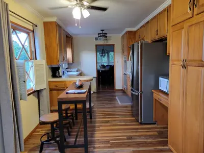 a kitchen with a table and a refrigerator at Extremely Chill 3 Bedroom Home in Long Beach