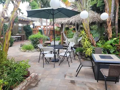 a patio with a table and chairs and an umbrella at Extremely Chill 3 Bedroom Home in Long Beach