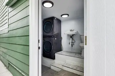 a bathroom with a washer and dryer next to a house at Home 1 Mi to DTLA Room to Work and Relax! in Los Angeles