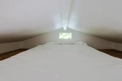 a white bed in a small room with a window at The Topanga Bungalow by Colby & Conrad in Topanga