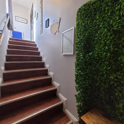 a stairway with a green wall next to a stair case at LA Getaway Oasis in Los Angeles
