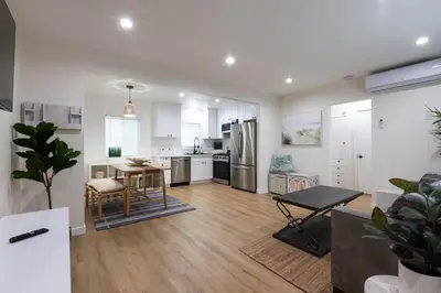 a kitchen and living room with a table and refrigerator at Stylish Long Beach Retreat Walk to Beach Bars in Long Beach