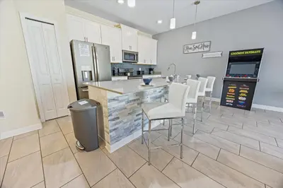 a kitchen with a bar with white chairs and a counter at LBL4837 in Los Angeles