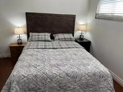 a bedroom with a large bed with two lamps at \u5b89\u9759\u6574\u6d01\u4fbf\u6377\u7684\u72ec\u7acb\u623f\u5b50 in Baldwin Park