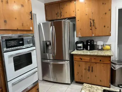 a kitchen with stainless steel appliances and wooden cabinets at \u5b89\u9759\u6574\u6d01\u4fbf\u6377\u7684\u72ec\u7acb\u623f\u5b50 in Baldwin Park