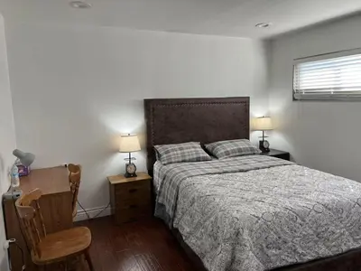a bedroom with a bed and a chair and two lamps at \u5b89\u9759\u6574\u6d01\u4fbf\u6377\u7684\u72ec\u7acb\u623f\u5b50 in Baldwin Park