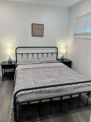 a bed in a bedroom with two nightstands and two lamps at \u4fbf\u6377\u5b9c\u5c45\u7684\u72ec\u7acb\u623f\u5b50 in Baldwin Park