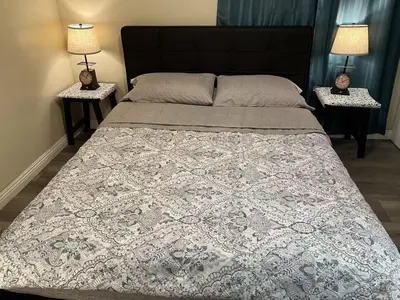 a bedroom with a large bed with two night stands at \u6b22\u8fce\u5165\u4f4fWest Covina\u7684\u56db\u5367\u4e8c\u536b\u7684\u72ec\u7acb\u623f\u5b50 in West Covina