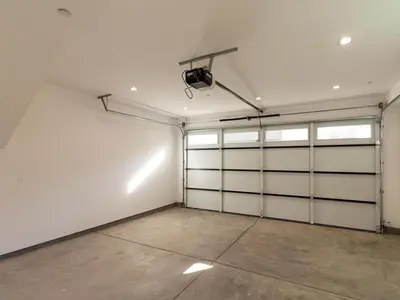 an empty garage with white doors and a spotlight at Modern Luxe Retreat Four-Bedroom in Los Angeles