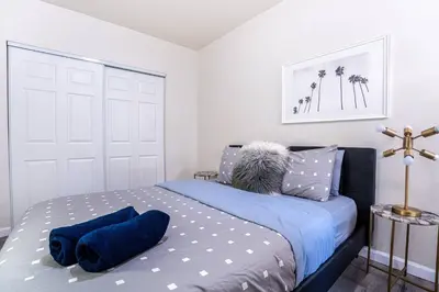 a bedroom with a bed with blue pillows on it at Comfy Home Near Sofi Stadium in Los Angeles