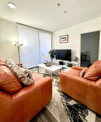 a living room with two orange couches and a tv at Beautiful 2bd 2bth apartment in Santa Monica in Los Angeles
