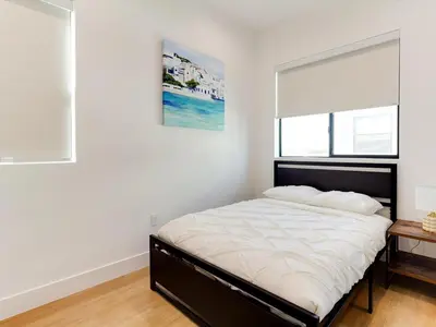 a bedroom with a large bed with a window and a bed frame at Modern Luxe Retreat Six-Bedroom in Los Angeles