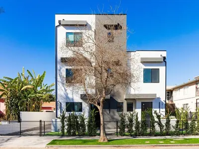 a tall white building with a tree in front of it at Modern Luxe Retreat Six-Bedroom in Los Angeles