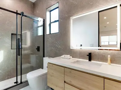 a bathroom with a sink and a toilet and a mirror at Modern Luxe Retreat Six-Bedroom in Los Angeles