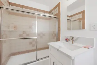 a white bathroom with a shower and a sink at Cozy, Luxurious, Oasis, With Free parking in Los Angeles