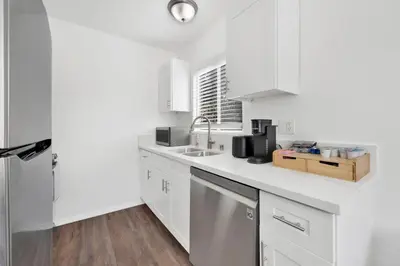 a white kitchen with white cabinets and a sink at Cozy, Luxurious, Oasis, With Free parking in Los Angeles