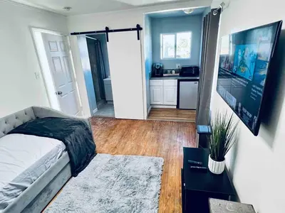 a bedroom with a bed and a tv in a room at Beautiful private upstairs studio - USC, LAX, SOFI in Los Angeles