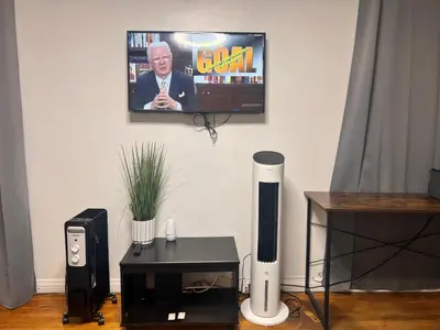 a living room with a television on a wall with a table at Beautiful private upstairs studio - USC, LAX, SOFI in Los Angeles