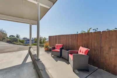a patio with two chairs and a fence at Whitney Oceanview Studio in Summerland