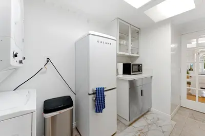 a white kitchen with a refrigerator and a microwave at The Hidden Hideaway in Summerland