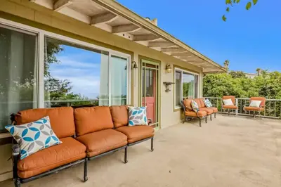 an orange couch sitting on a porch with windows at Summerland Beach Oasis- Pet Friendly in Summerland