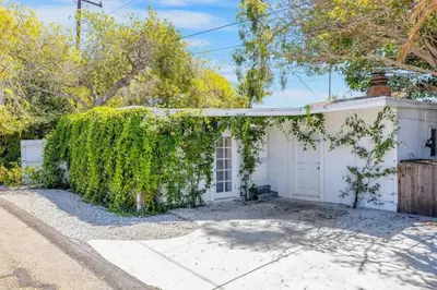 a white house with a ivy covered garage at Gillians Room- Pet Friendly in Summerland