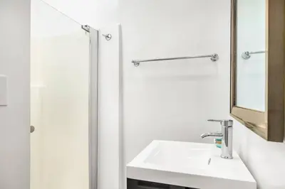 a white bathroom with a sink and a mirror at Gillians Room- Pet Friendly in Summerland