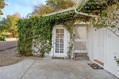 a white house with ivy growing around the door at Gillians Room- Pet Friendly in Summerland