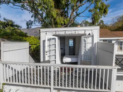 a white house with a porch and a balcony at The Grand Escape - Casita Sonrisa in Summerland