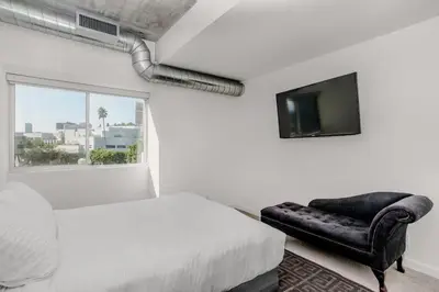 a bedroom with a bed and a chair and a window at On Sunset Blvd - 5 star retreat in Los Angeles