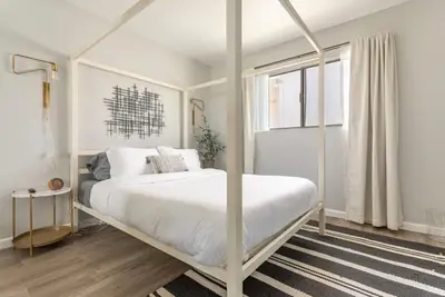 a white bedroom with a white canopy bed in it at 3BR Townhouse in Prime Manhattan Beach Location in Manhattan Beach