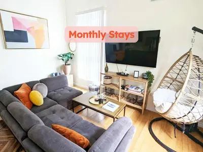 a living room with a couch and a tv at Seaside Sanctuary - Rooftop Deck & Hot Tub in Hermosa Beach