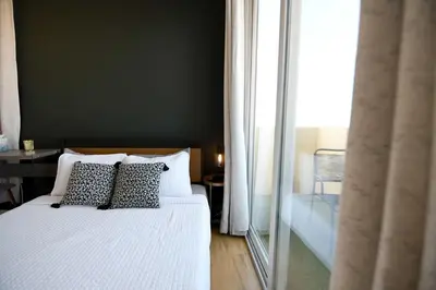 a bedroom with a white bed and a large window at Seaside Sanctuary - Rooftop Deck & Hot Tub in Hermosa Beach