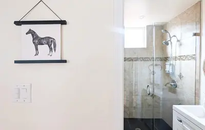 a bathroom with a picture of a horse on the wall at Seaside Sanctuary - Rooftop Deck & Hot Tub in Hermosa Beach