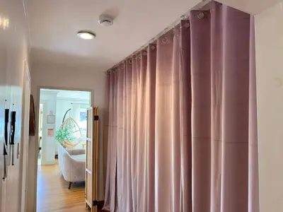 a living room with pink curtains and a couch at Charming 1920s Hermosa Bungalow Steps from The Strand in Hermosa Beach