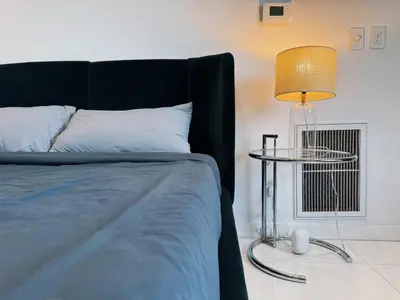 a bedroom with a bed and a table with a lamp at Hollywood hill stunning view cozy private room in Los Angeles